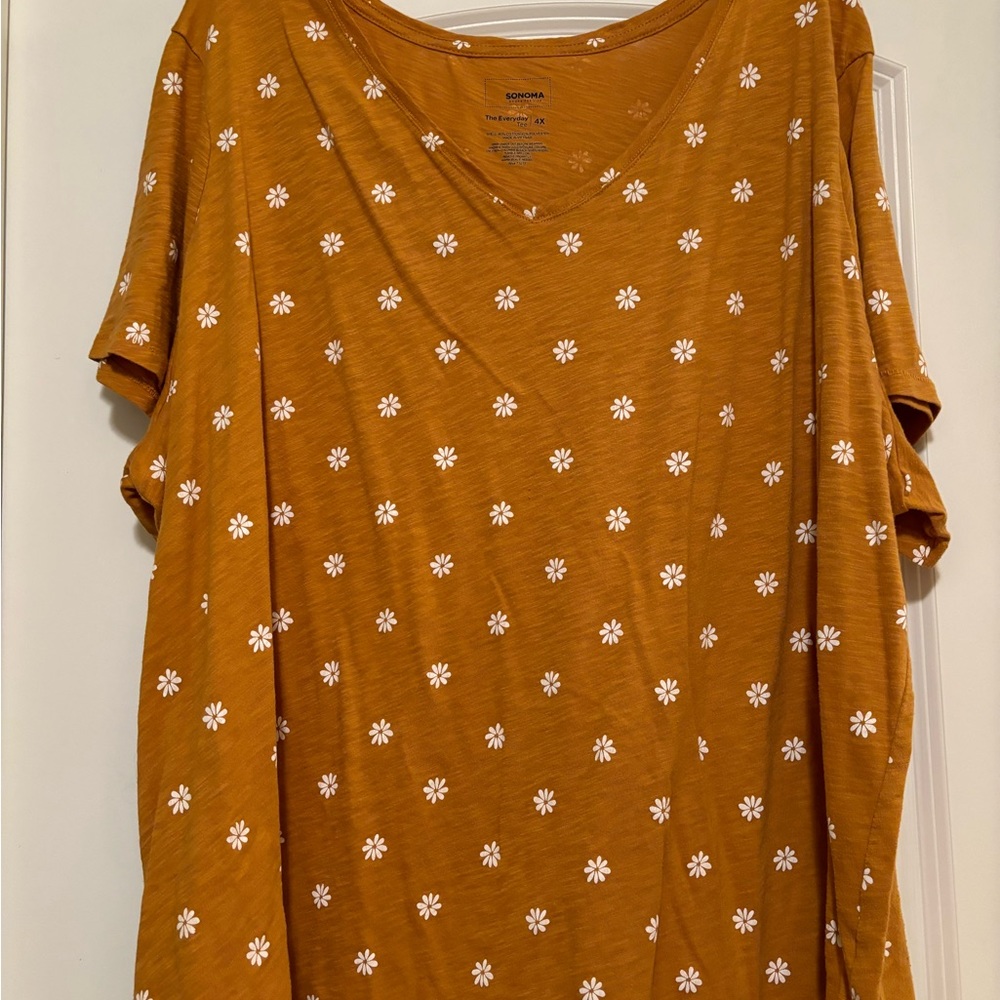 Gold t-shirt with white flowers.